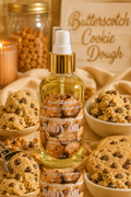 A bottle of 'The Candle Shop' Butterscotch Cookie Dough Body Oil is centered, surrounded by bowls of chocolate chip cookies, cookies and cream, and jars of ingredients, with a wooden sign reading 'Butterscotch Cookie Dough' in the background.