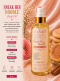A bottle of Candi Shop Sneak Her Doodle body oil displayed on a warm pink satin background with cookies, cinnamon sticks, and a rose. The left side includes scent notes and descriptive text.